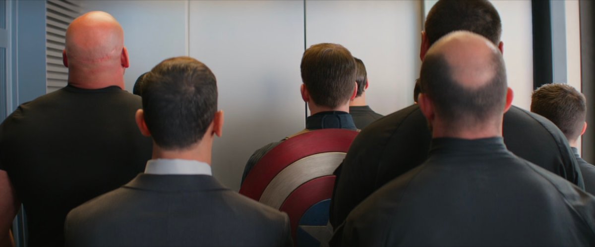 Steve Rogers stands in an elevator with a number of HYDRA thugs.