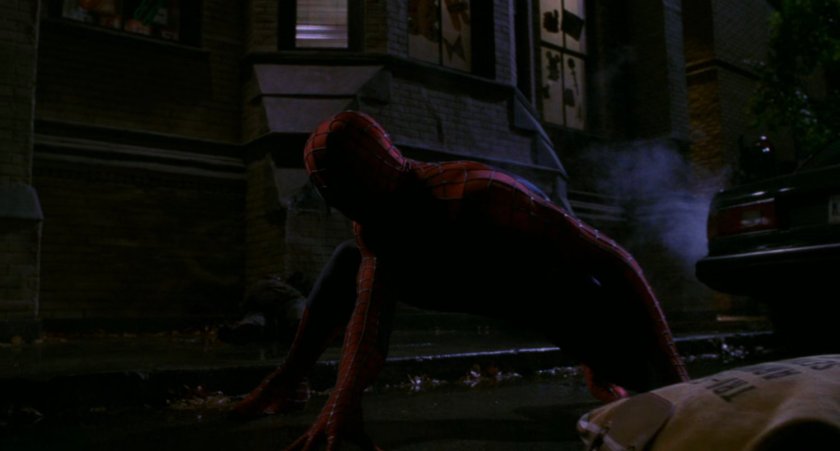 Spider-Man in hero pose on street.
